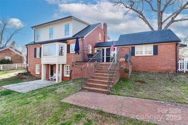 view of front of house featuring fence, stairway, a patio, and brick siding