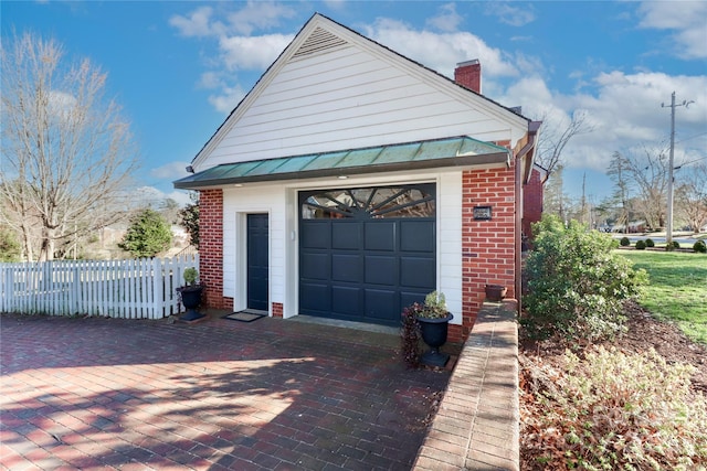 detached garage featuring driveway and fence