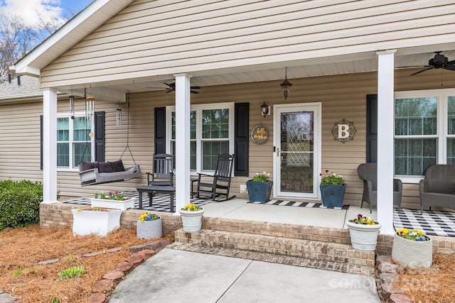 entrance to property featuring covered porch and ceiling fan