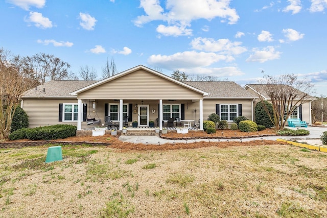 single story home featuring covered porch and a front yard