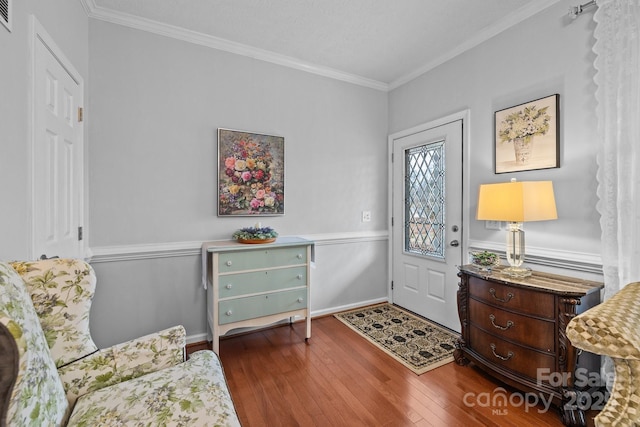 entrance foyer featuring visible vents, hardwood / wood-style floors, and crown molding