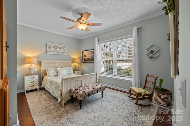 bedroom featuring crown molding, ceiling fan, baseboards, wood finished floors, and a textured ceiling