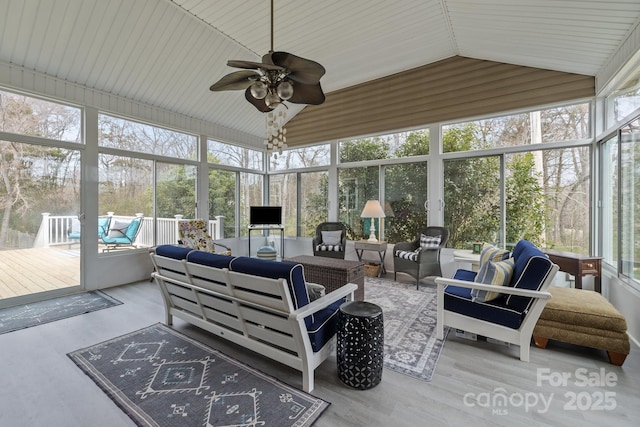 sunroom / solarium with lofted ceiling, plenty of natural light, and a ceiling fan