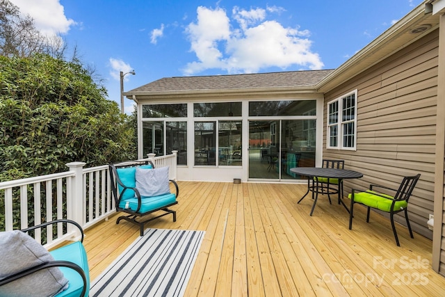 wooden deck with a sunroom