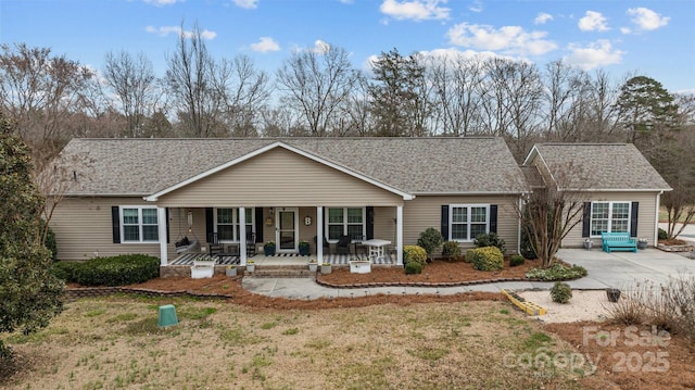 ranch-style house featuring covered porch and roof with shingles