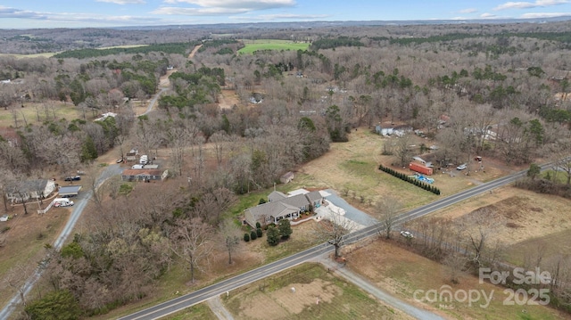 drone / aerial view featuring a rural view and a wooded view