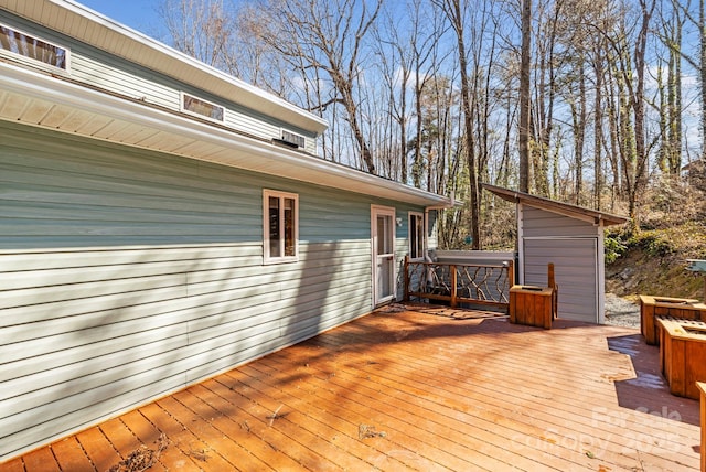 deck with a storage shed, a jacuzzi, and an outdoor structure