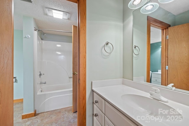 full bathroom featuring baseboards, tub / shower combination, a textured ceiling, and vanity