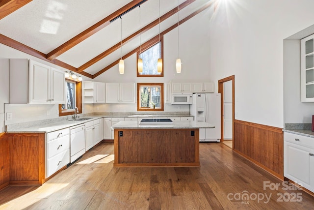 kitchen featuring a center island, white appliances, white cabinets, and a sink