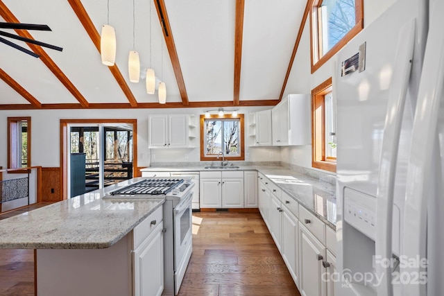 kitchen featuring a center island, decorative light fixtures, open shelves, white cabinets, and white appliances