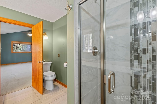 bathroom featuring lofted ceiling, a textured ceiling, toilet, baseboards, and a shower stall