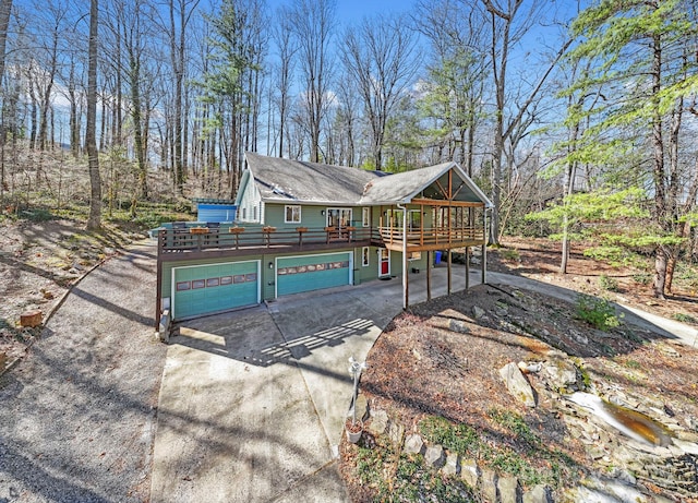 view of front of property featuring concrete driveway and a wooden deck