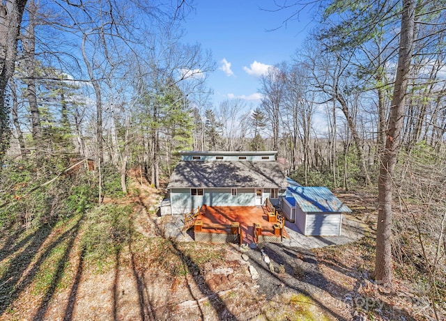 rear view of property featuring dirt driveway and a deck