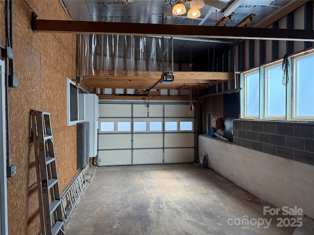 garage with concrete block wall and a garage door opener