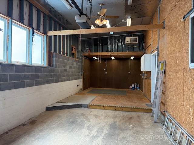 interior space with concrete block wall and a ceiling fan