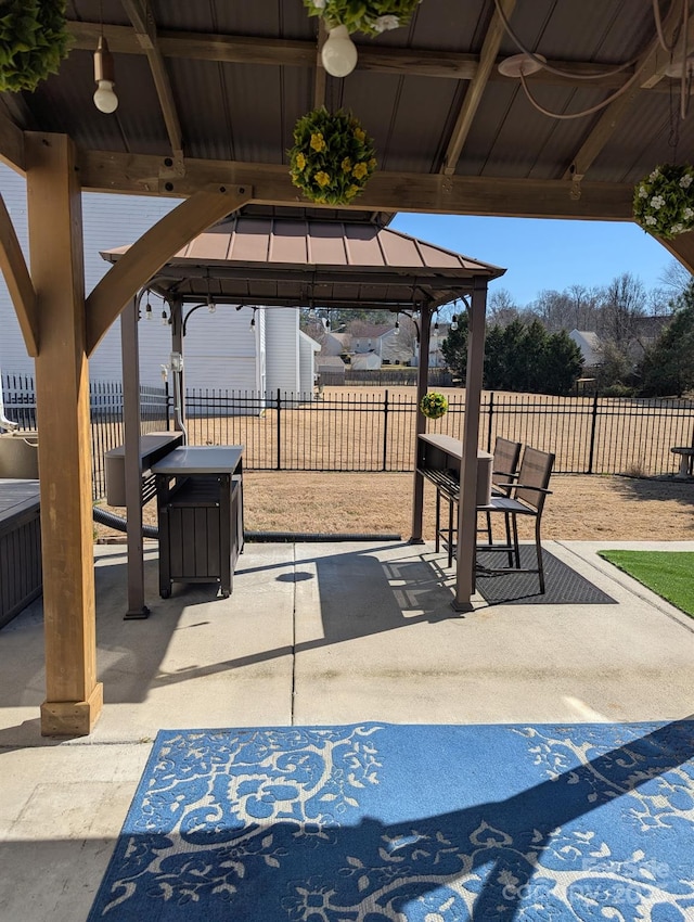 view of patio / terrace featuring outdoor dining space, fence, and a gazebo