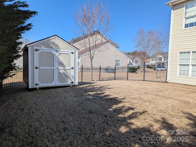 view of yard with fence, a storage unit, and an outdoor structure