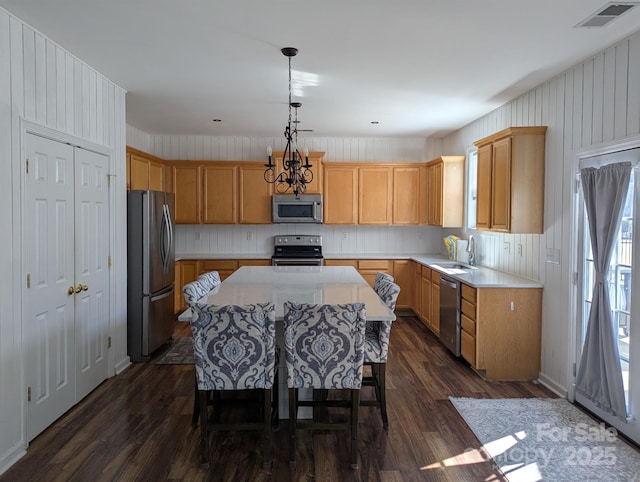 kitchen featuring dark wood-style floors, light countertops, visible vents, appliances with stainless steel finishes, and a sink