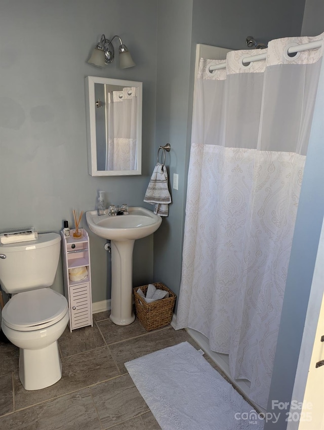 bathroom with a shower with shower curtain and toilet