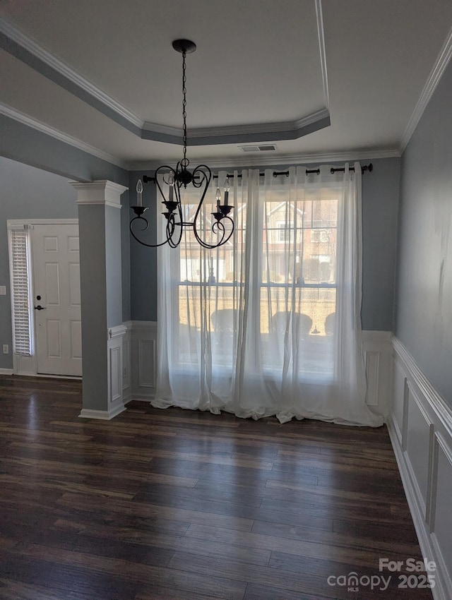 unfurnished dining area featuring crown molding, visible vents, a raised ceiling, and dark wood-style flooring