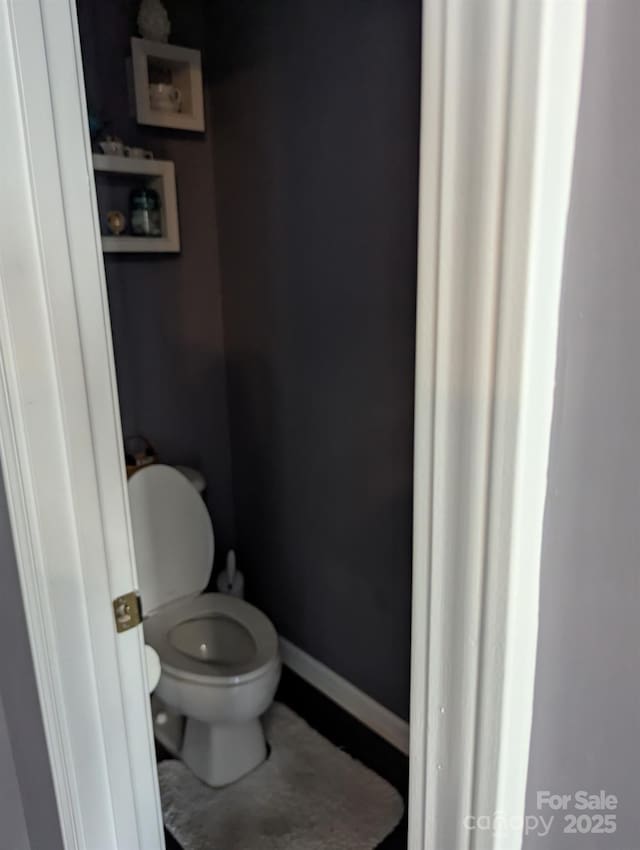 bathroom featuring baseboards and toilet