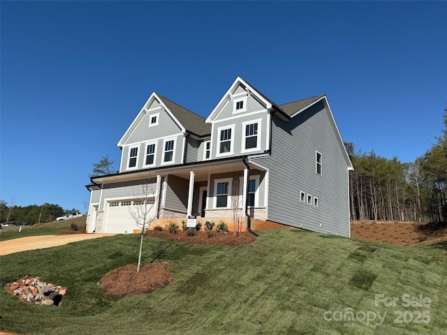 traditional-style home with a garage, concrete driveway, covered porch, a front lawn, and board and batten siding