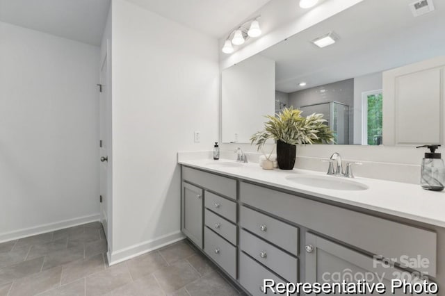 bathroom with double vanity, a stall shower, visible vents, and a sink