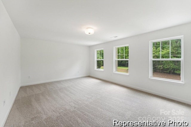 unfurnished room featuring carpet floors and baseboards