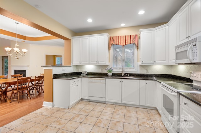 kitchen with white appliances, light tile patterned floors, a sink, white cabinets, and backsplash