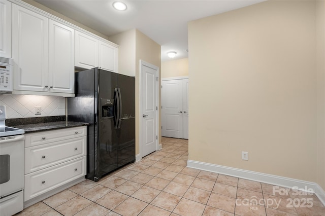 kitchen with white appliances, light tile patterned floors, white cabinets, dark countertops, and tasteful backsplash