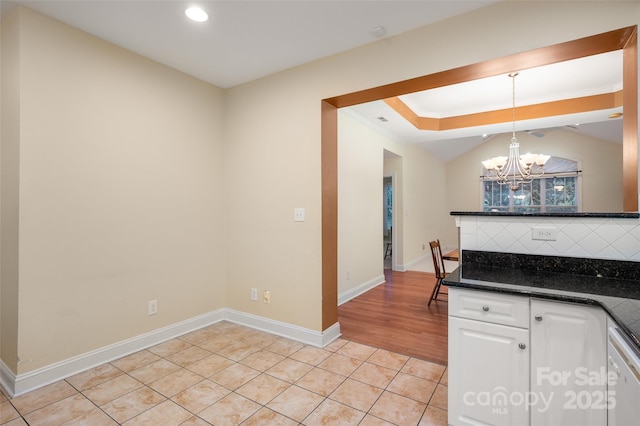 kitchen featuring backsplash, a chandelier, decorative light fixtures, light tile patterned floors, and white cabinets