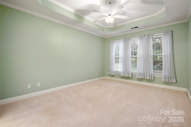 spare room with visible vents, baseboards, ceiling fan, light colored carpet, and a raised ceiling