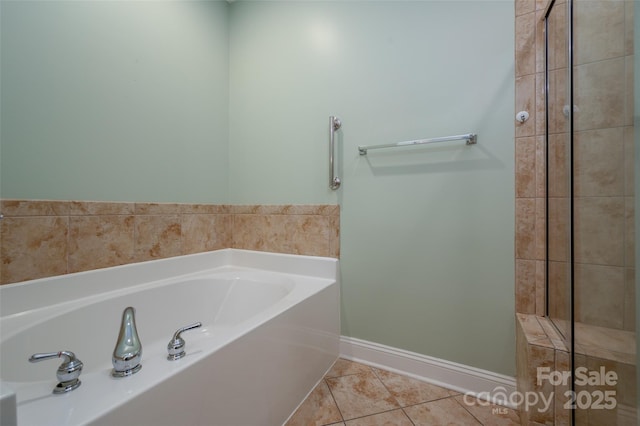 bathroom with tile patterned flooring, a garden tub, and baseboards