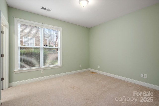 carpeted empty room with visible vents and baseboards