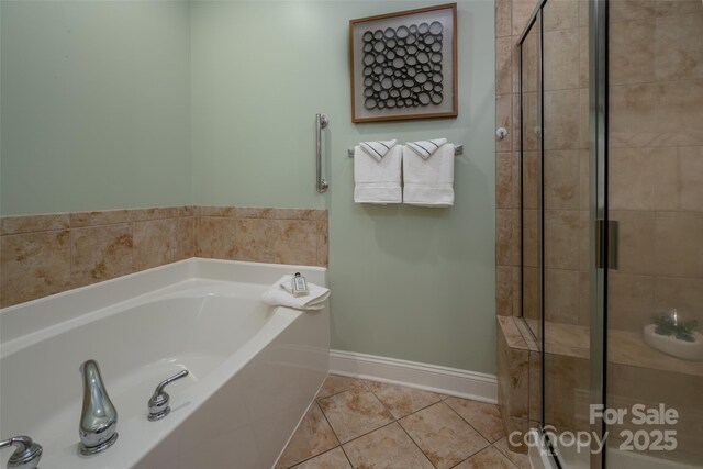 full bath with baseboards, a bath, a shower stall, and tile patterned flooring