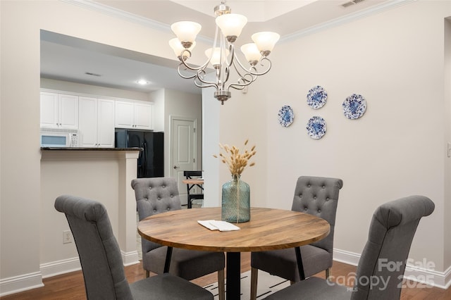dining space featuring a chandelier, baseboards, ornamental molding, and dark wood-type flooring