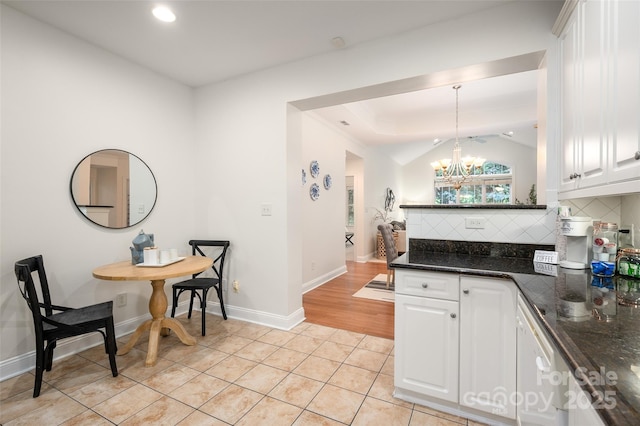 kitchen with light tile patterned floors, white cabinets, and backsplash