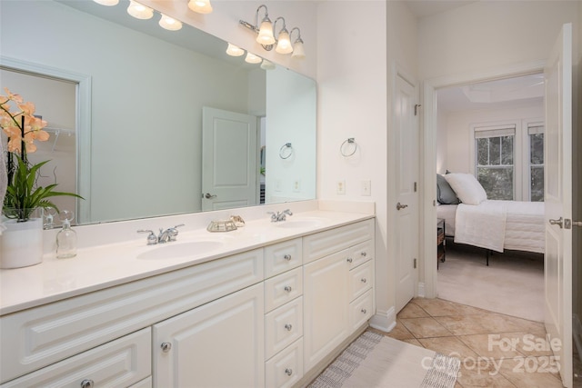 full bathroom featuring double vanity, a closet, tile patterned flooring, and a sink