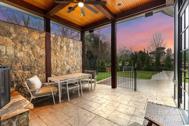 patio terrace at dusk with outdoor dining space and a ceiling fan