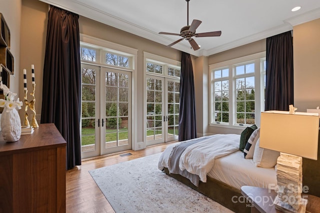 bedroom with crown molding, access to outside, wood finished floors, and french doors