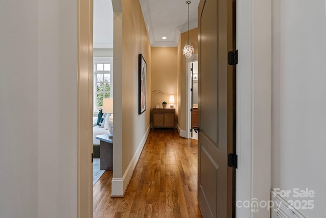 hall featuring recessed lighting, wood finished floors, baseboards, and ornamental molding