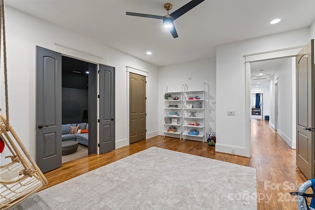 interior space with recessed lighting, ceiling fan, baseboards, and wood finished floors