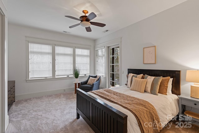 carpeted bedroom featuring a ceiling fan, visible vents, and baseboards