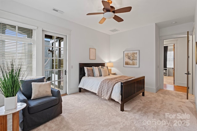 carpeted bedroom with visible vents, multiple windows, and access to outside