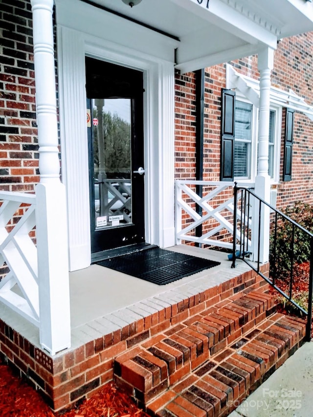 doorway to property featuring brick siding