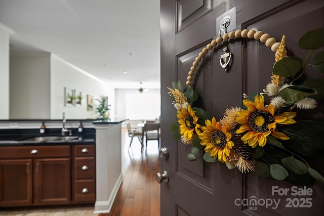 kitchen featuring light wood-type flooring, dark countertops, and a sink