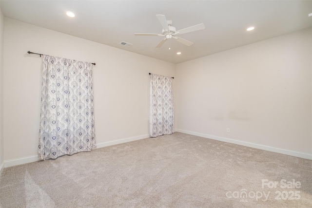 spare room featuring recessed lighting, light colored carpet, and baseboards