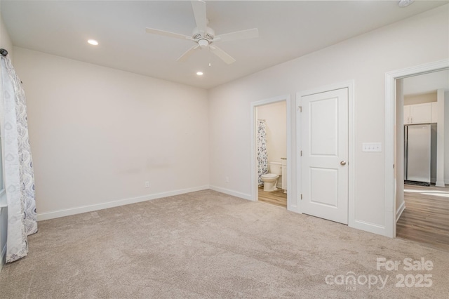 unfurnished bedroom with recessed lighting, baseboards, light colored carpet, and freestanding refrigerator