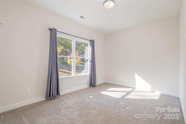 unfurnished room featuring light colored carpet, visible vents, and baseboards