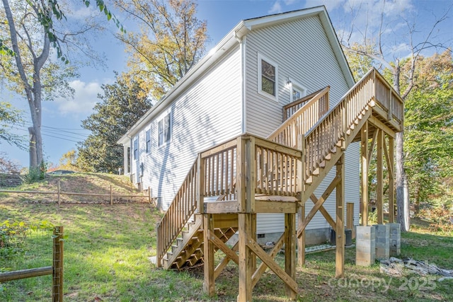 rear view of property featuring a lawn, stairway, crawl space, fence, and a deck